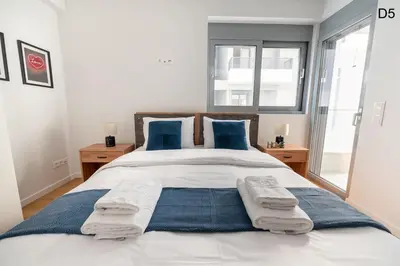 a bedroom with a large bed with blue pillows at Waylink Residences - Marina Floisvou - Z4 in Athens