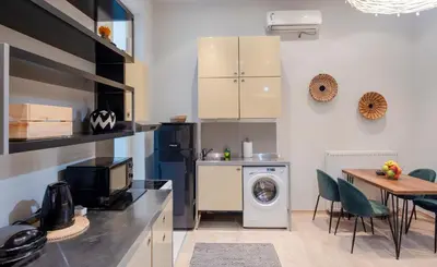 a kitchen with a washing machine and a table at K8 Syntagma in Athens