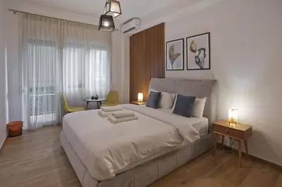 a bedroom with a large white bed with two lamps at Bellissimo Ctr Stylish Reno 2BR Apt near Acropolis in Athens