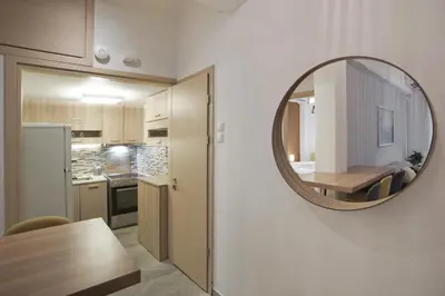 a kitchen and dining room with a mirror on the wall at Bellissimo Ctr Stylish Reno 2BR Apt near Acropolis in Athens