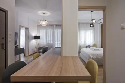 a room with a wooden table and a bedroom at Bellissimo Ctr Stylish Reno 2BR Apt near Acropolis in Athens
