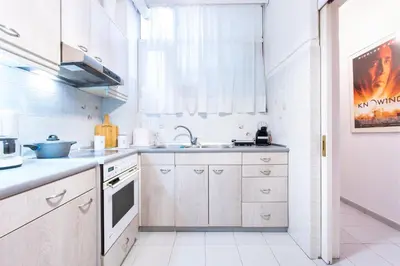 a kitchen with white cabinets and a sink at Modern Apartment near City center in Athens