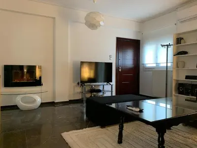 a living room with a coffee table and a tv at Quiet apartment in Athens