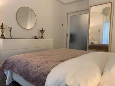 a bedroom with a large bed and a mirror at Quiet apartment in Athens