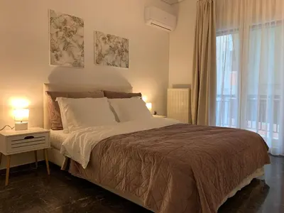 a bedroom with a large bed and a window at Quiet apartment in Athens
