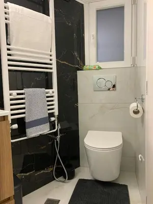 a bathroom with a white toilet and a window at Quiet apartment in Athens