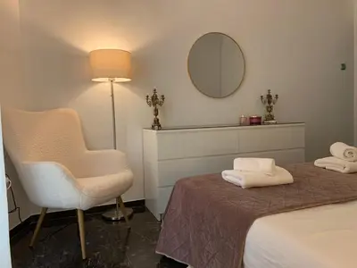 a bedroom with a bed and a chair and a mirror at Quiet apartment in Athens