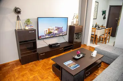 a living room with a large flat screen tv at Stephan's Modern Apartment in Athens