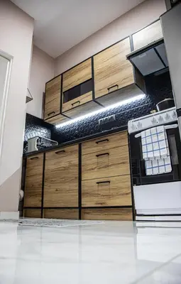 a kitchen with wooden cabinets and a stove at Stephan's Modern Apartment in Athens