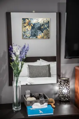 a bedroom with a bed with a mirror above a table at Stephan's Modern Apartment in Athens