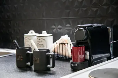 a counter with three coffee cups and a coffee maker at Stephan's Modern Apartment in Athens