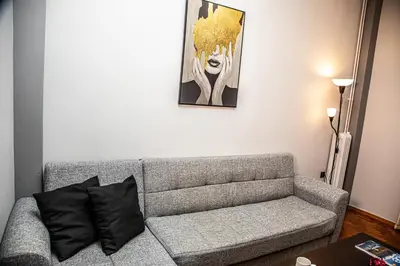 a living room with a couch and a painting on the wall at Stephan's Modern Apartment in Athens