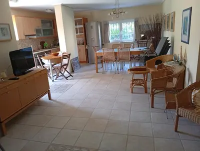 a living room with a kitchen and a dining room at Cosy garden house in a villa in Palaiá Fókaia
