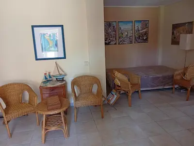 a room with a bed and chairs and a table at Cosy garden house in a villa in Palaiá Fókaia