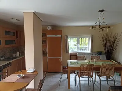 a kitchen and dining room with a table and chairs at Cosy garden house in a villa in Palaiá Fókaia