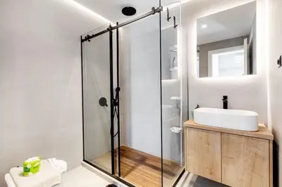 a bathroom with a glass shower and a sink at Brisk - Chic 1 Bedroom Apartment in Athens in Athens