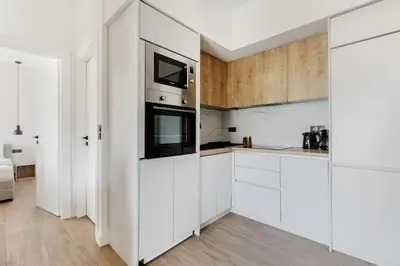 a white kitchen with white cabinets and appliances at Brisk - Chic 1 Bedroom Apartment in Athens in Athens