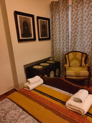 a bedroom with a bed with a chair and towels at Pythagoras Omonoia in Athens