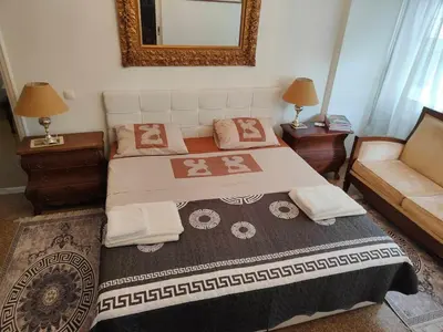 a bedroom with a bed and a couch and a mirror at Pythagoras Omonoia in Athens