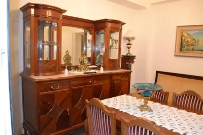 a dining room with a table and a large wooden cabinet at Pythagoras Omonoia in Athens