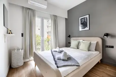 a bedroom with a large white bed with a window at Bask - Glamorous 2 Bedroom Apartment in Athens in Athens