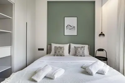 a bedroom with a large white bed with two pillows at Bask - Glamorous 2 Bedroom Apartment in Athens in Athens