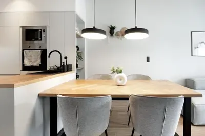 a kitchen and dining room with a wooden table and chairs at Bask - Glamorous 2 Bedroom Apartment in Athens in Athens