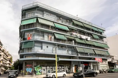 a tall building with cars parked in front of it at Bask - Glamorous 2 Bedroom Apartment in Athens in Athens