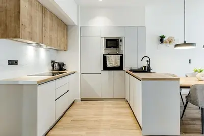 a kitchen with white cabinets and a counter top at Bask - Glamorous 2 Bedroom Apartment in Athens in Athens