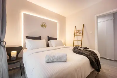 a bedroom with a large white bed with a towel on it at Elegant Aphrodite, 2 Bedroom Apartment, by Acropolin in Athens