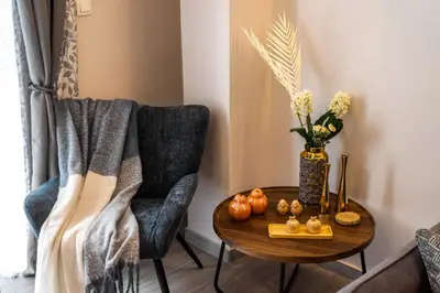 a table with a vase of flowers and a table with chairs at Elegant Aphrodite, 2 Bedroom Apartment, by Acropolin in Athens