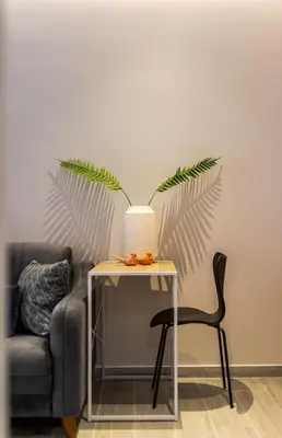 a table with a plant on it next to a chair at Elegant Aphrodite, 2 Bedroom Apartment, by Acropolin in Athens