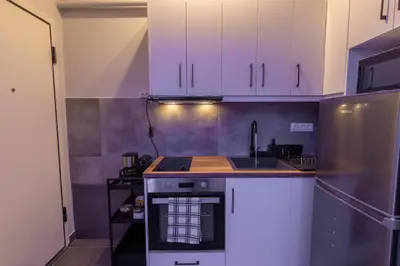 a kitchen with white cabinets and a stainless steel refrigerator at Athens Center Retreat in Athens