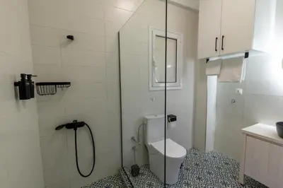 a bathroom with a toilet and a glass shower at Athens Center Retreat in Athens