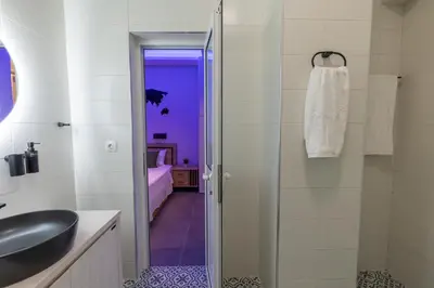 a bathroom with a sink and a glass shower door at Athens Center Retreat in Athens