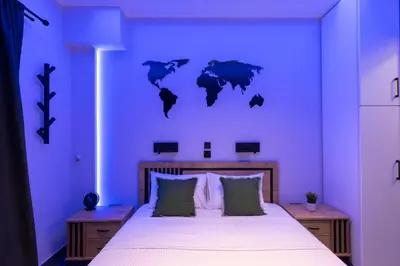a bedroom with a large bed with a blue wall at Athens Center Retreat in Athens
