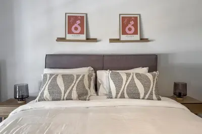 a bedroom with a bed with three pictures on the wall at Phaedrus Living Koukaki Verdant Marble in Athens