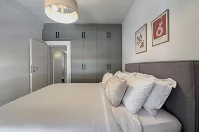 a bedroom with a bed with white sheets and pillows at Phaedrus Living Koukaki Verdant Marble in Athens