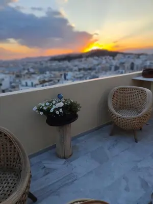 a balcony with two chairs and a table with flowers at Pythagoras Acropolis in Athens