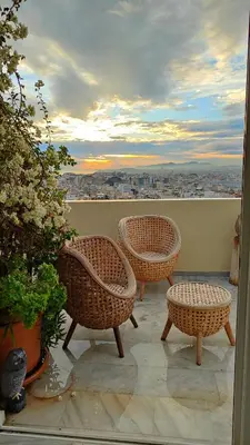 three wicker chairs and a table on a balcony at Pythagoras Acropolis in Athens