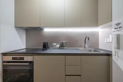a white kitchen with a sink and a stove at Zen Tulip, Kolonaki in Athens