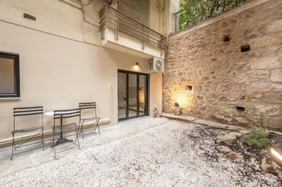a patio with chairs and a brick wall at Zen Tulip, Kolonaki in Athens