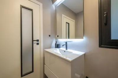 a white bathroom with a sink and a mirror at Zen Tulip, Kolonaki in Athens