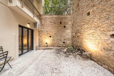 an exterior view of a stone building with a stone wall at Zen Tulip, Kolonaki in Athens