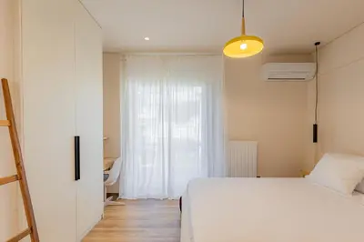 a bedroom with a white bed and a window at Mandarin One Bedroom Apartment Varkiza in Vari