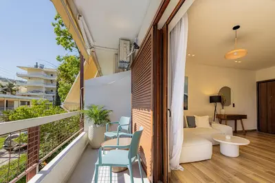 a balcony with a couch and a table and chairs at Mandarin One Bedroom Apartment Varkiza in Vari