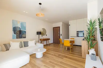 a living room with a white couch and a table at Mandarin One Bedroom Apartment Varkiza in Vari