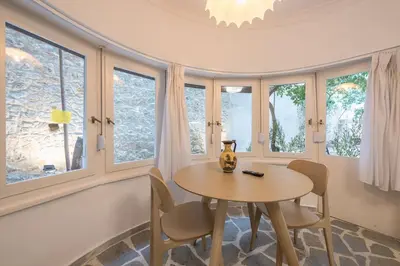 a dining room with a table and chairs and windows at Zen Lotus, Kolonaki in Athens