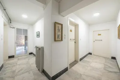 a hallway with white walls and a door and a tile floor at Zen Lotus, Kolonaki in Athens