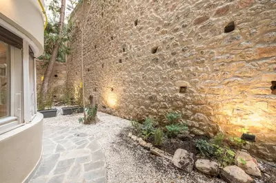 a stone wall with a window and some plants at Zen Lotus, Kolonaki in Athens